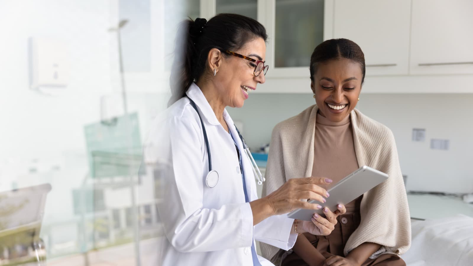 A clinician reviewing results on a tablet with a smiling patient